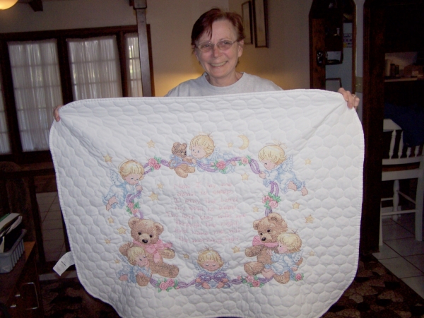 Carol showing off a baby blanket she made